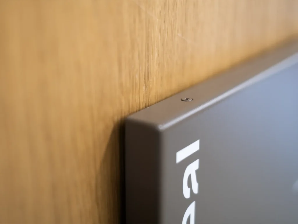 Detail mit Schattenfuge und Senkkopfschraube in gleicher Farbe wie das Schild